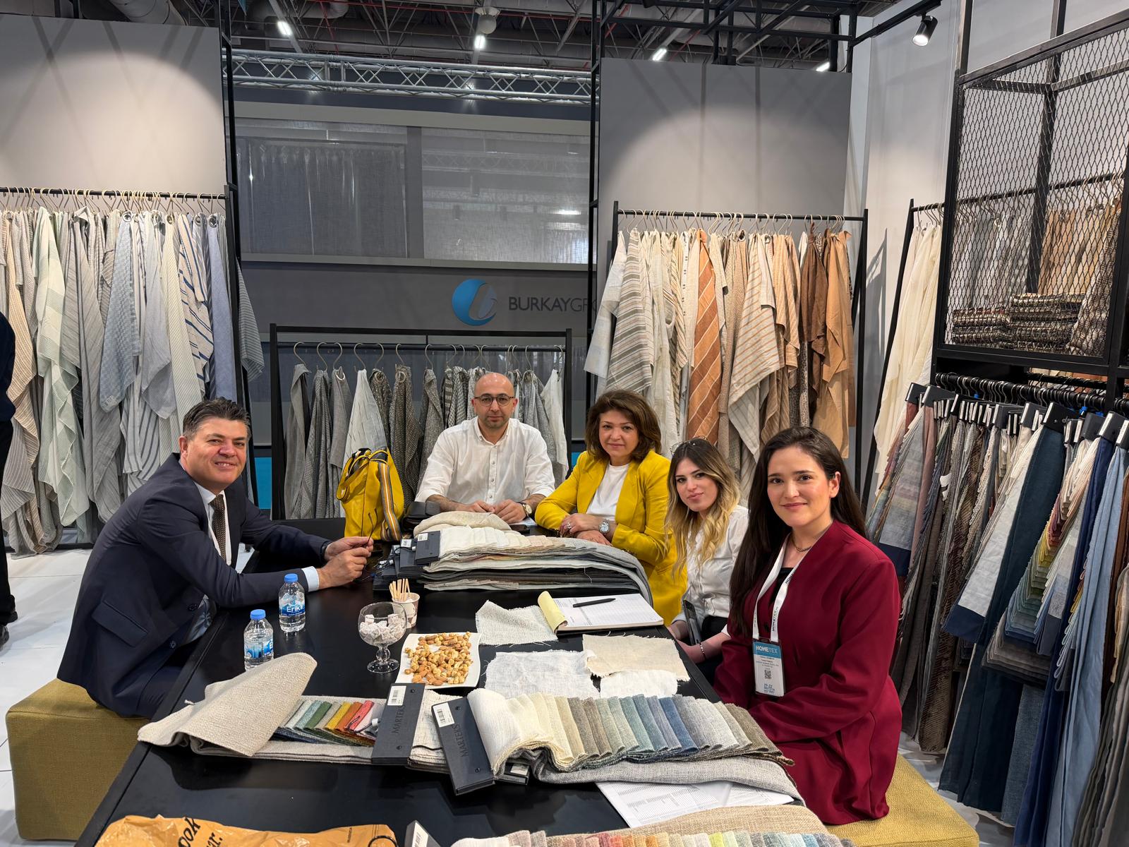 Abdullah AĞAR of MGM-EMEA meeting Turkish home textile suppliers at HOMETEX 2026 in Istanbul with fabric samples on the table